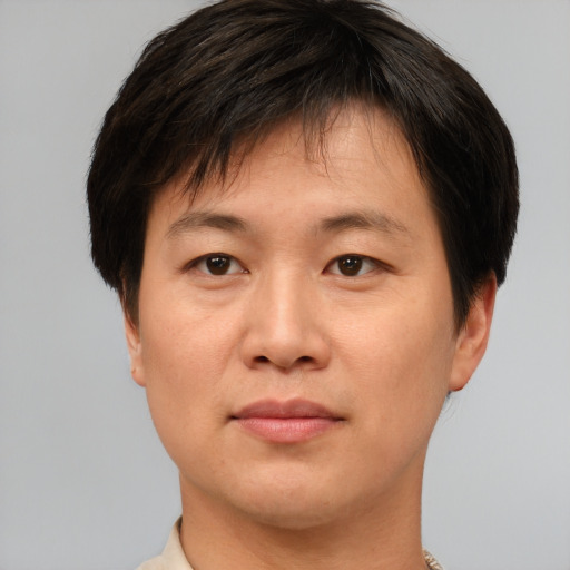 Joyful asian young-adult male with short  brown hair and brown eyes