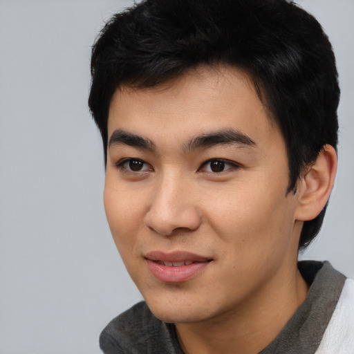 Joyful asian young-adult male with short  black hair and brown eyes