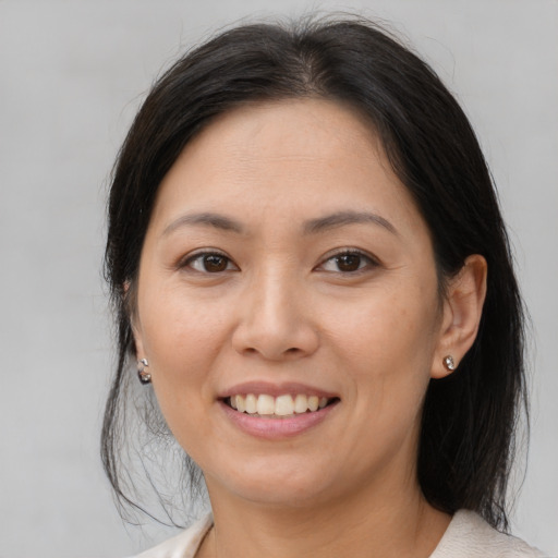 Joyful asian young-adult female with medium  brown hair and brown eyes