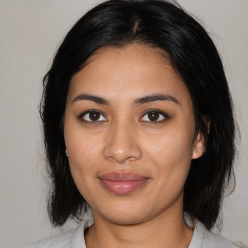 Joyful latino young-adult female with medium  black hair and brown eyes