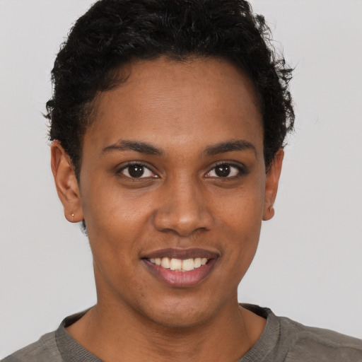 Joyful black young-adult female with short  brown hair and brown eyes