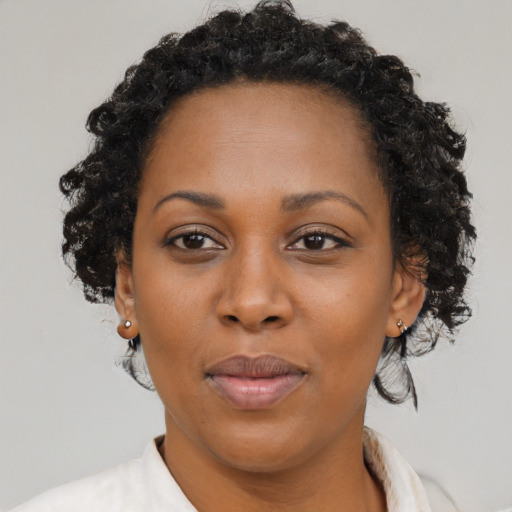 Joyful black adult female with medium  brown hair and brown eyes