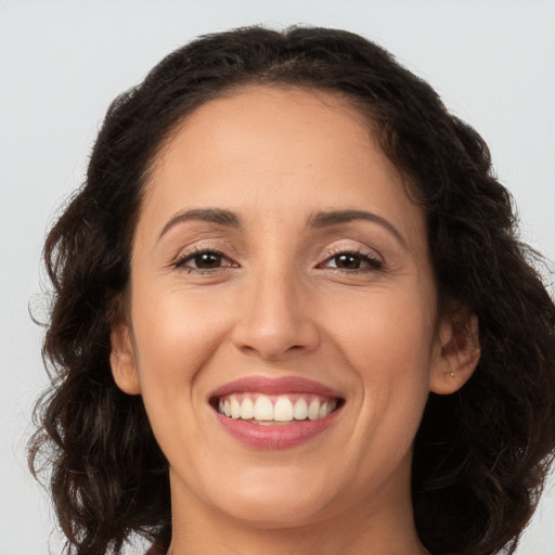 Joyful white adult female with long  brown hair and brown eyes