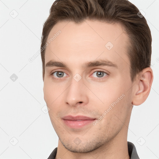 Joyful white young-adult male with short  brown hair and grey eyes