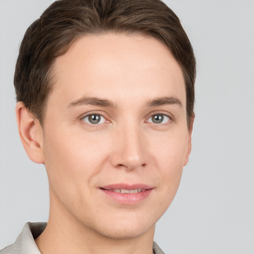 Joyful white young-adult male with short  brown hair and grey eyes