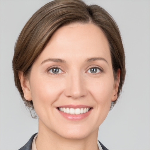 Joyful white young-adult female with medium  brown hair and grey eyes