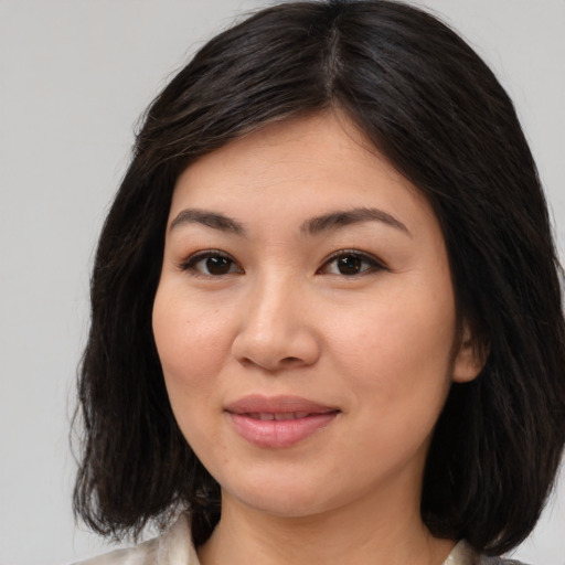 Joyful asian young-adult female with medium  brown hair and brown eyes