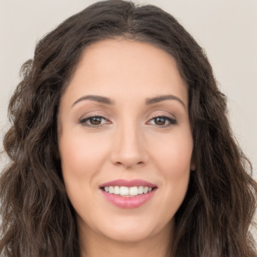 Joyful white young-adult female with long  brown hair and brown eyes