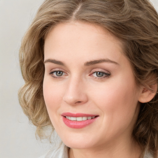 Joyful white young-adult female with medium  brown hair and green eyes