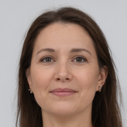 Joyful white adult female with long  brown hair and grey eyes