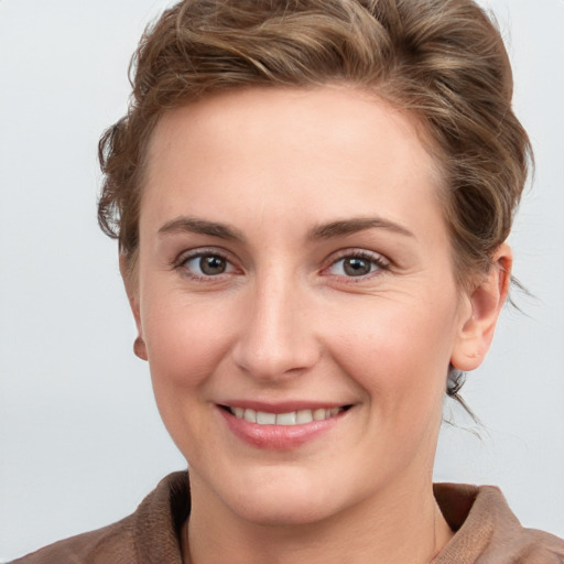 Joyful white young-adult female with short  brown hair and grey eyes