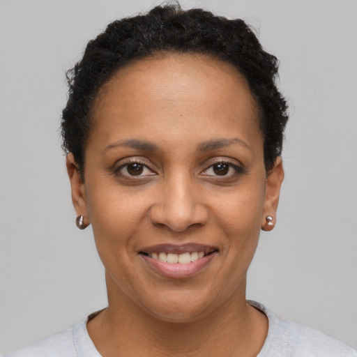 Joyful black young-adult female with short  brown hair and brown eyes