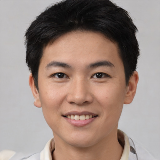Joyful asian young-adult male with short  brown hair and brown eyes