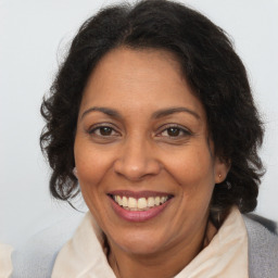 Joyful latino adult female with medium  brown hair and brown eyes