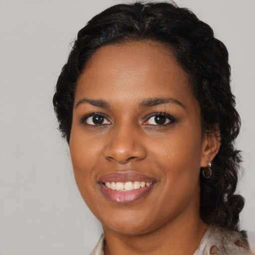 Joyful black young-adult female with long  black hair and brown eyes