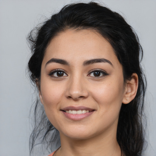 Joyful latino young-adult female with long  black hair and brown eyes