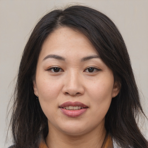 Joyful asian young-adult female with long  brown hair and brown eyes