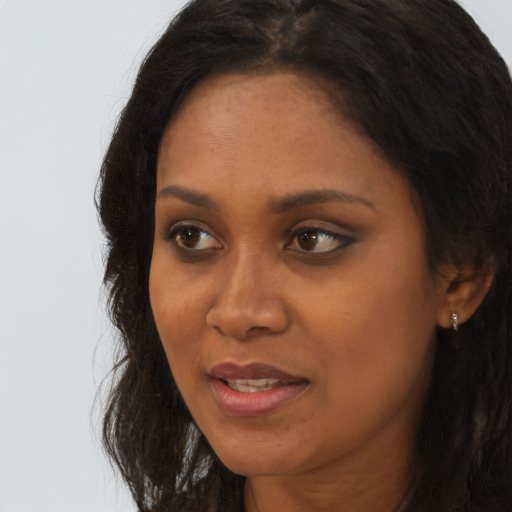 Joyful black adult female with long  brown hair and brown eyes