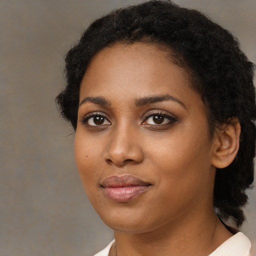 Joyful black young-adult female with medium  brown hair and brown eyes