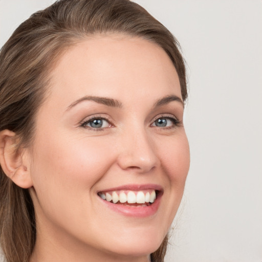 Joyful white young-adult female with long  brown hair and grey eyes