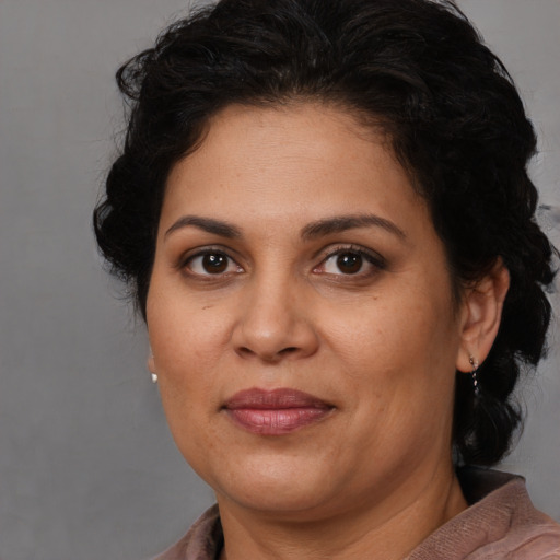 Joyful latino adult female with medium  brown hair and brown eyes