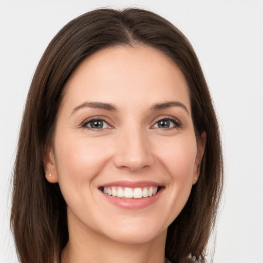 Joyful white young-adult female with long  brown hair and grey eyes