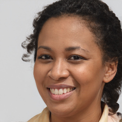Joyful black young-adult female with medium  brown hair and brown eyes