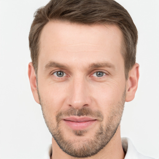 Joyful white young-adult male with short  brown hair and grey eyes