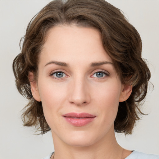 Joyful white young-adult female with medium  brown hair and green eyes