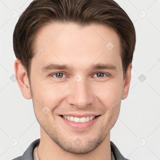 Joyful white young-adult male with short  brown hair and grey eyes