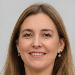 Joyful white adult female with long  brown hair and grey eyes