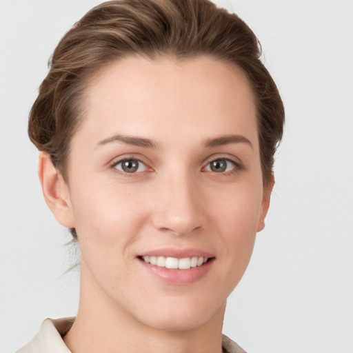 Joyful white young-adult female with short  brown hair and grey eyes