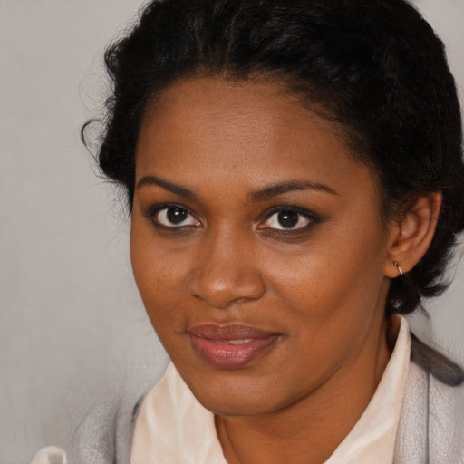 Joyful black young-adult female with short  brown hair and brown eyes