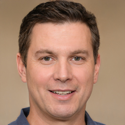 Joyful white adult male with short  brown hair and grey eyes