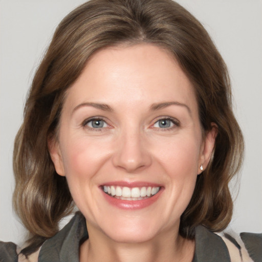 Joyful white adult female with medium  brown hair and grey eyes