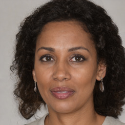 Joyful black adult female with medium  brown hair and brown eyes