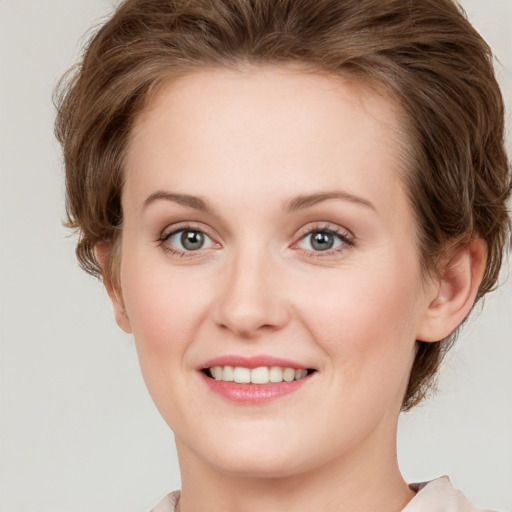 Joyful white young-adult female with short  brown hair and grey eyes