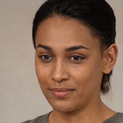 Joyful black young-adult female with medium  brown hair and brown eyes