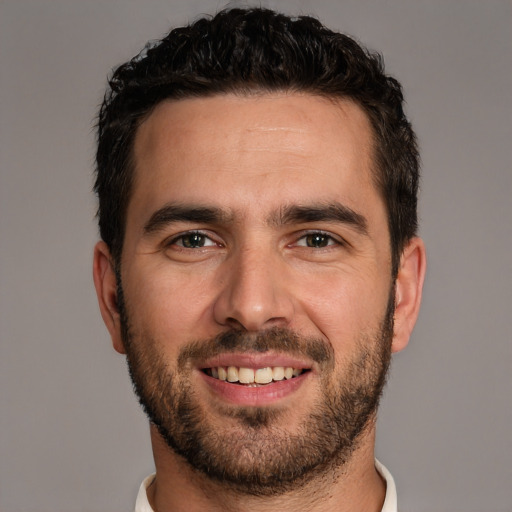 Joyful white young-adult male with short  black hair and brown eyes