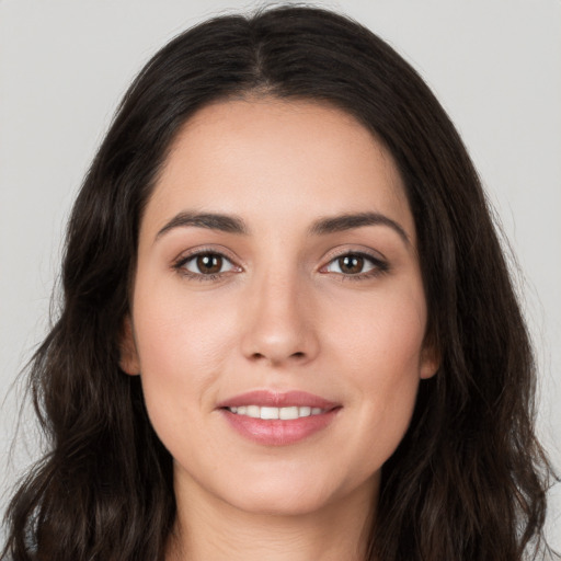 Joyful white young-adult female with long  brown hair and brown eyes