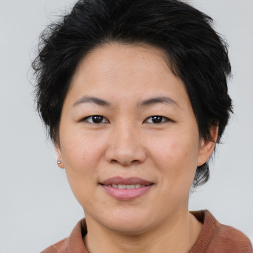 Joyful asian adult female with medium  brown hair and brown eyes