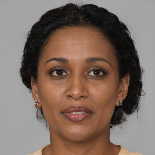 Joyful black adult female with medium  brown hair and brown eyes