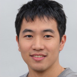 Joyful asian young-adult male with short  black hair and brown eyes