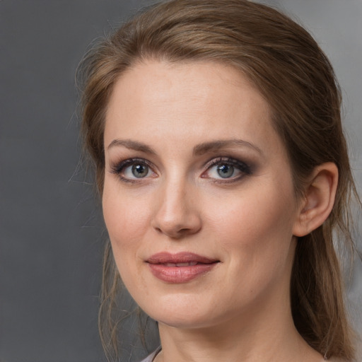 Joyful white young-adult female with medium  brown hair and grey eyes