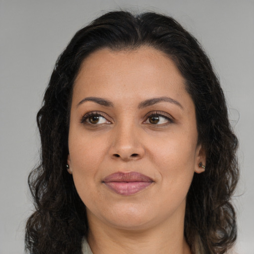 Joyful latino adult female with long  brown hair and brown eyes