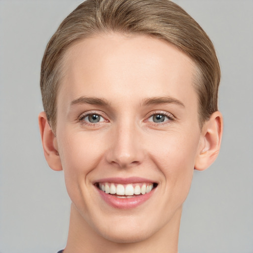 Joyful white young-adult female with short  brown hair and grey eyes