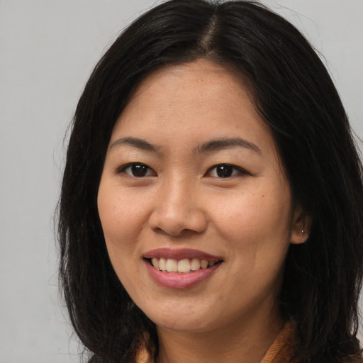 Joyful asian young-adult female with long  brown hair and brown eyes