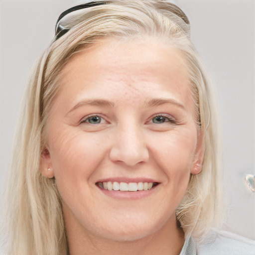 Joyful white young-adult female with long  blond hair and blue eyes