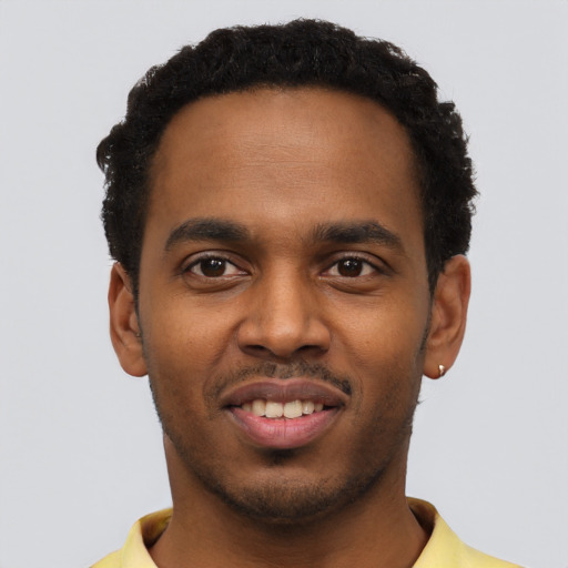 Joyful black young-adult male with short  black hair and brown eyes