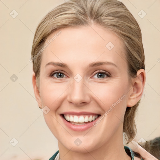 Joyful white young-adult female with medium  brown hair and blue eyes